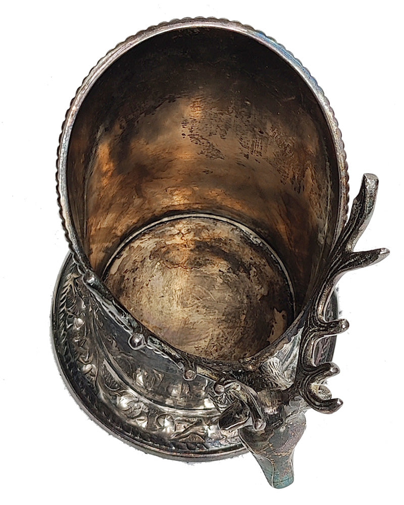 A silver vintage wine of champagne bottle holder with a stag head detail top